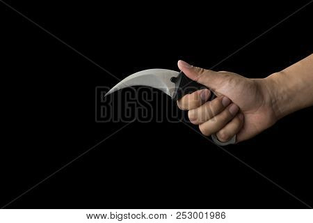 Close Up Of Hand Holding A Karambit Knife, Isolated On Black Background With Clipping Path