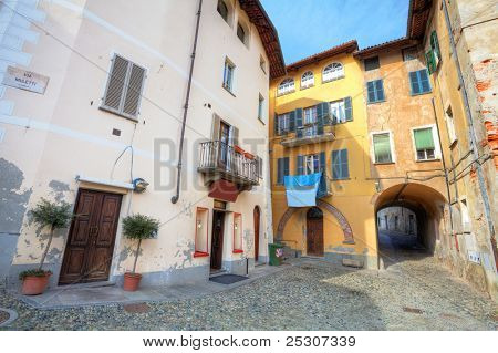Kleinen schmalen gepflasterten Straße zwischen bunten Häusern in der Stadt von Saluzzo, Norditalien.