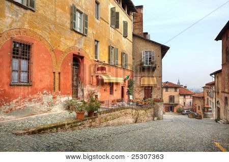 Schmalen gepflasterten Straße zwischen Vintage bunten Häusern in Stadt Saluzzo, Norditalien.