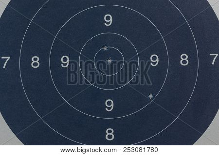 Bullet holes in the black target by a gun