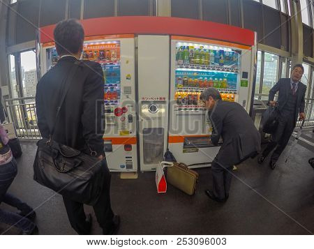 Tokyo, Japan - April 27, 2016: Japanese Salary Man Picking His Drink Up From Drinking Vending Machin