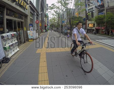 Fukuoka, Japan - April 25, 2016: A Young Man Biking On Street, He Seems To Go To Work