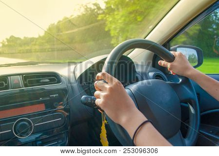 Tan-skinned Woman Hands Controling Car Steering Wheel