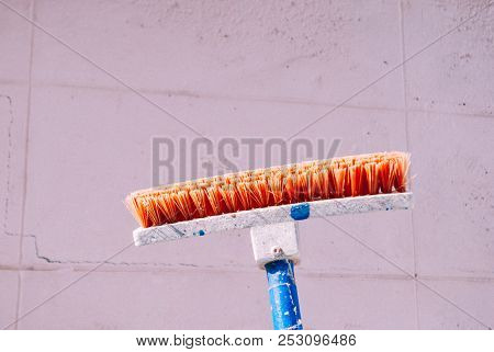 Orange Cleaning Brush On The Concrete Wall