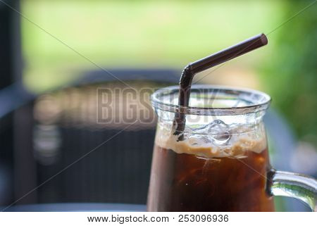 Close Up Iced Espresso Coffee With Brown Straw In Crystal High-shape Glass On The Table At Coffee Sh
