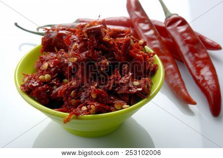Red chilly chutney and chilies on white background. a rural food item in India.
