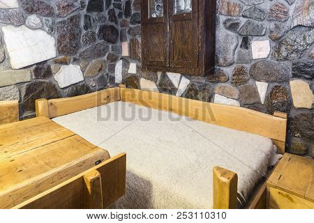 Traditional Romanian Wooden Bed Covered By A Whool Blanket (cerga) In A Hostel Chalet In Transylvani