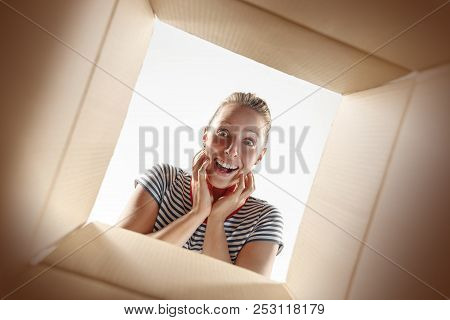 The Surprised Woman Unpacking, Opening Carton Box And Looking Inside. The Package, Delivery, Surpris