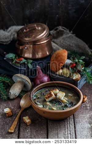 Mushroom Soup In Ceramic Bowl With A Copper Pan And Mushroom In Background, Dark Photo.
