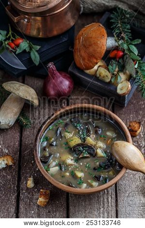 Mushroom Soup In Ceramic Bowl With A Copper Pan And Mushroom In Background, Dark Photo.