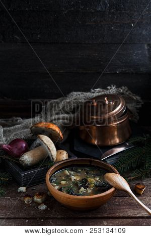 Mushroom Soup In Ceramic Bowl With A Copper Pan And Mushroom In Background, Dark Photo, Copy Space.