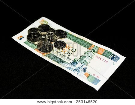 Cinco Pesos Paper Bill Known As Cuc With Coins On It With A Black Background.