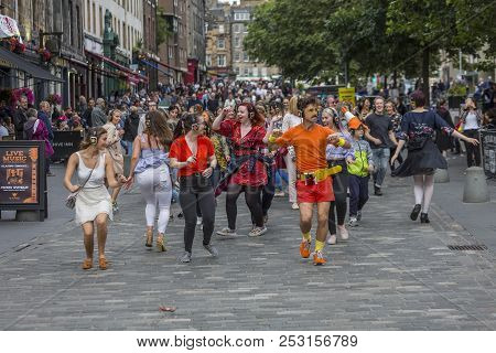 Edinburgh, Scotland  - August 7: A Jubilant Group Dances On The Sidewalk At The Edinburgh Fringe Fes