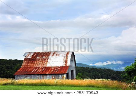 Tin Barn Sits At The Top Of An Ozark Mountain.  Scenic View Overlooks Ozarks And Clouds.