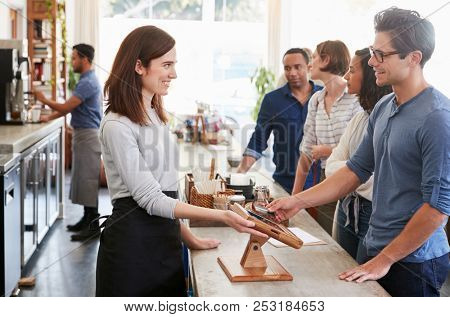 Customers queuing to order and pay at a coffee shop