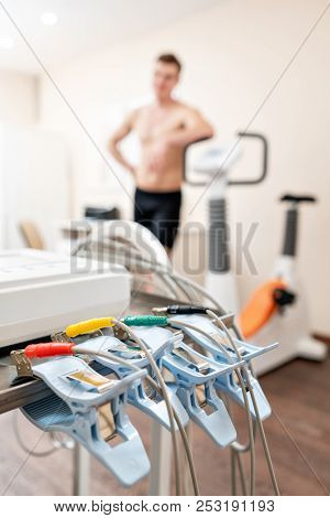 Clothespins Of The Ecg Machine In The Foreground. Athlete Does A Cardiac Stress Test And Vo2 In A Me