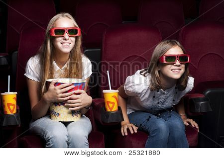 zwei schöne Mädchen, die einen Film im Kino