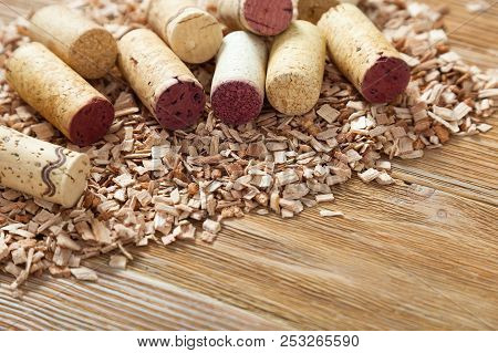 Corks With Red Stain  Lie In A Stack On Background From Wood Chips. Natural Wood Fon With Heap Of Co