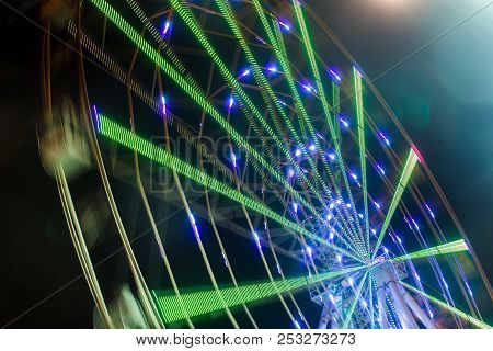 Carnival Ride Showing A Spinning Ferris Wheel In Action- Long Exposure Shot