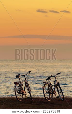 Silhouette Of Two Bicycles By The Sea After Sunset