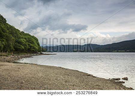 An Image Of The Shoreline And Dramatic Sky At Coniston Water, Lake District, Cumbria, England, Uk.