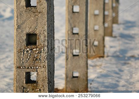 Detail Of Hayrack Pillars In Winter Side-lit By Golden Sunlight