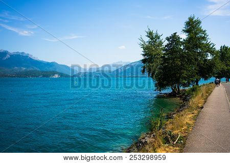 Scenic View Of Annecy Lake Showing Crystal Clear Water And Pathway Along The Lake In Haute-savoie Fr