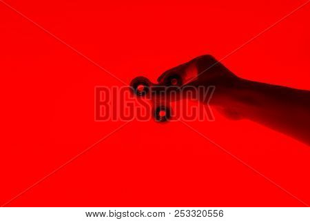 Hand Holding Popular Trendy Typical Three-bladed Fidget Spinner On Red Background