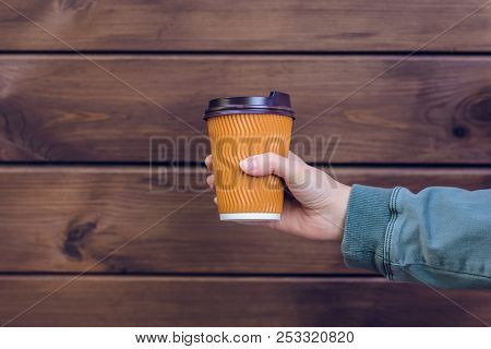 I Love Coffee! Person's Hand Holding Cup Of Coffee In Front Of Brown Wooden Background