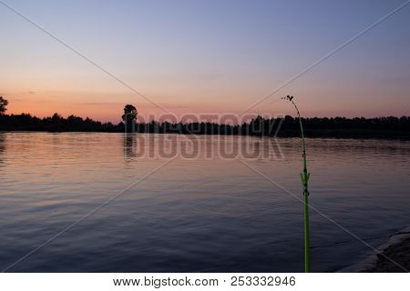 Evening Feeder Fishing On The River Bank Against The Background Of The Sunset