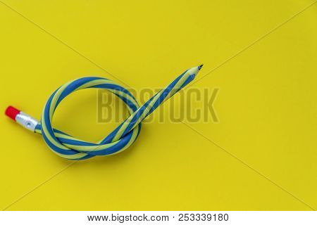 Knotted Striped Pencil With Pink Erazer Lying On Yellow Background, Concept Of Disappeared Inspirati