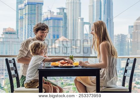 Happy Family Having Breakfast On The Balcony. Breakfast Table With Coffee Fruit And Bread Croisant O