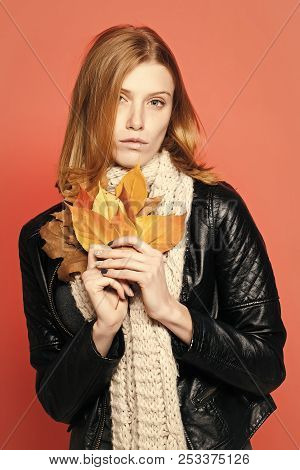 Woman With Autumn Leaves In Leather Jacket And Scarf On Orange Background