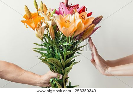 Hand Gives Bouquet Of Lilies Flowers To Girl And Receives Refusal, Woman Refuses And Shows Stop Sign