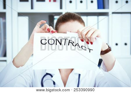 Hands Of Female Medicine Doctor Ripping Contract. Photo With Depth Of Field.