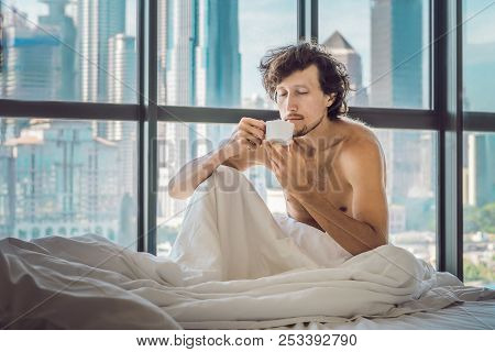Man Wakes Up In The Morning In An Apartment In The Downtown Area With A View Of The Skyscrapers And 