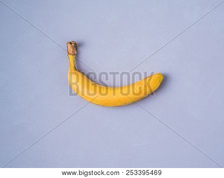 One Banana On Violet Lavener Colour Background. Creative Layer Of Banana. Single Ripe Banana Fruit T