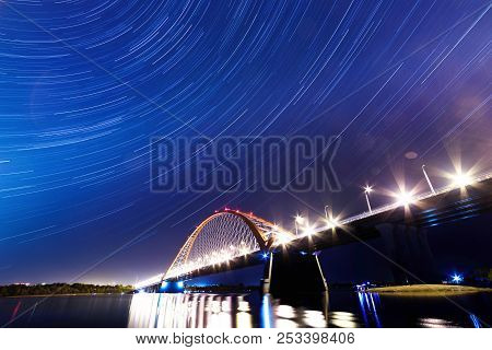 Bridge Over The River Ob Night. The Lights Of The Bridge Glow In The Night Sky.
In The Sky Are Visib