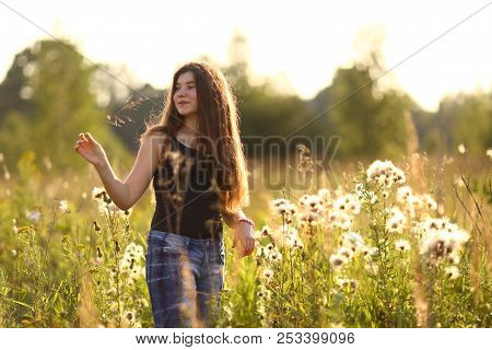 Teenager Girl With Long Brown Hair In Black Tank Top On Summer Sunset Field Horizontal Photo