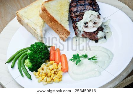 Roasted Black Pepper Lamb Steak With Salads And Fries On A Blue Round Plate. Wooden Texture Backgrou