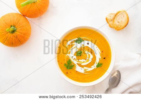 Pumpkin Soup With Cream And Pumpkin Seeds Isolated On White Background. Autumn Concept.