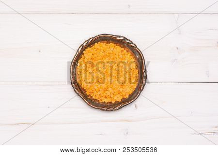 Lot Of Whole Raw Red Lentils In Old Iron Bowl Flatlay On Grey Wood