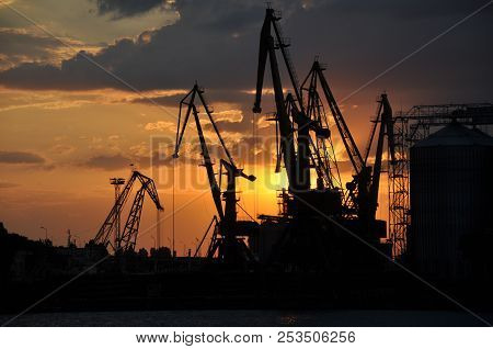 In The Rays Of The Sun. Sea ​​cargo Port At Sunset.