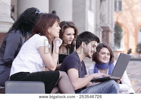 Group Of Fellow Students With Books And Laptop