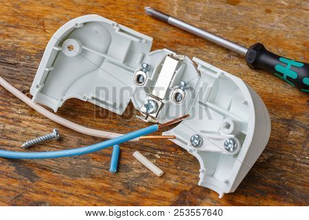 Electrical Plug With Copper Wires And Screwdriver On Wooden Table In Workshop