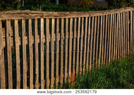Sunshine Creating Lens Flare Through A Wooden Picket Fence In A Front Yard, Front Garden With Artifi