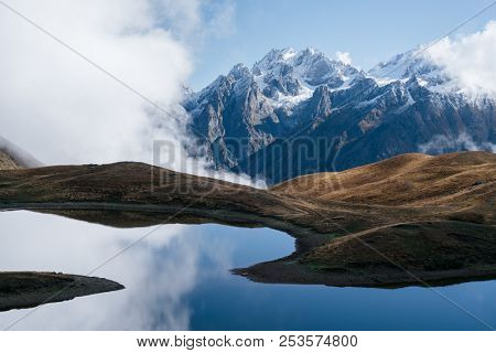 Landscape with a mountain lake. Day with beautiful clouds. Lake Koruldi. Main Caucasian ridge. Zemo Svaneti, Georgia