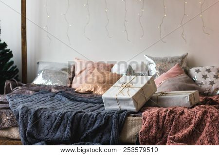 Xmas In Morning Bedroom. Double Bed In Christmas Interior On White Wall Background With Cozy Lights.