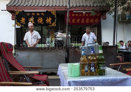 Dunhuang, China - August 7, 2012: Street Scene In The City Of Dunhuang, With Two Cookers In A Food S