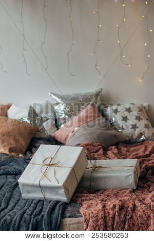 Xmas In Morning Bedroom. Double Bed In Christmas Interior On White Wall Background With Cozy Lights.